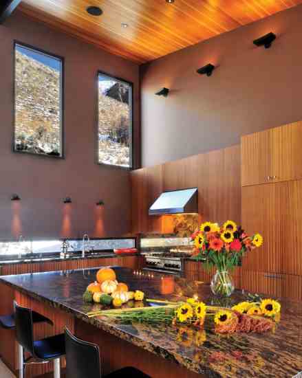 Tom and Katherine love to entertain in the kitchen, where guests often linger over long meals. High ceilings and windows make the eat-in kitchen feel larger than it is. The vertical grain of the sustainably harvested mahogany cabinetry elongates the room even more.
